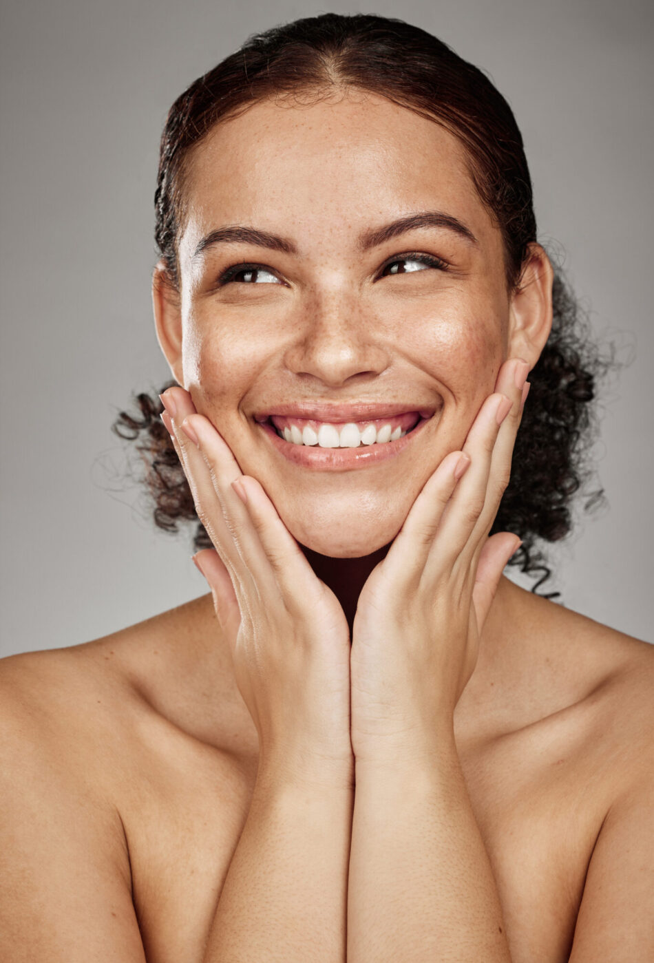 Face portrait, skincare and beauty of woman in studio isolated on a gray background. Thinking, makeup cosmetics and happy female model satisfied after spa facial treatment for healthy or glowing skin